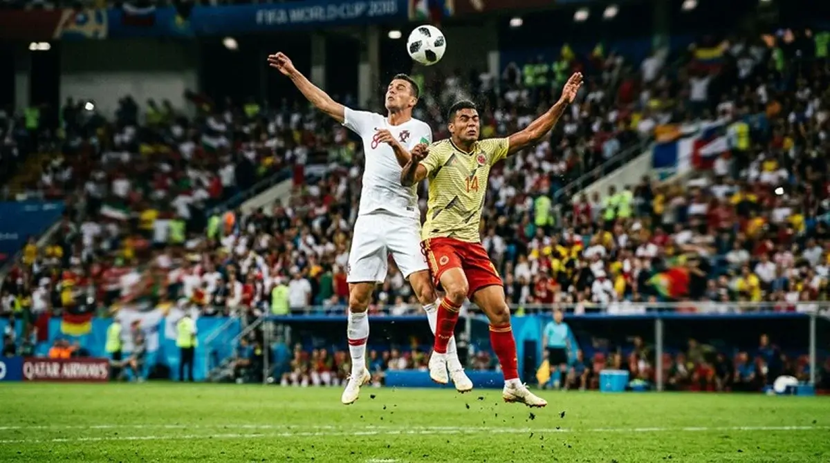Jugadores de fútbol disputando un balón en un partido nocturno del Mundial 2026
